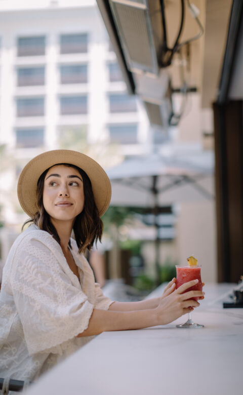 Woman enjoying a cocktail at a poolside